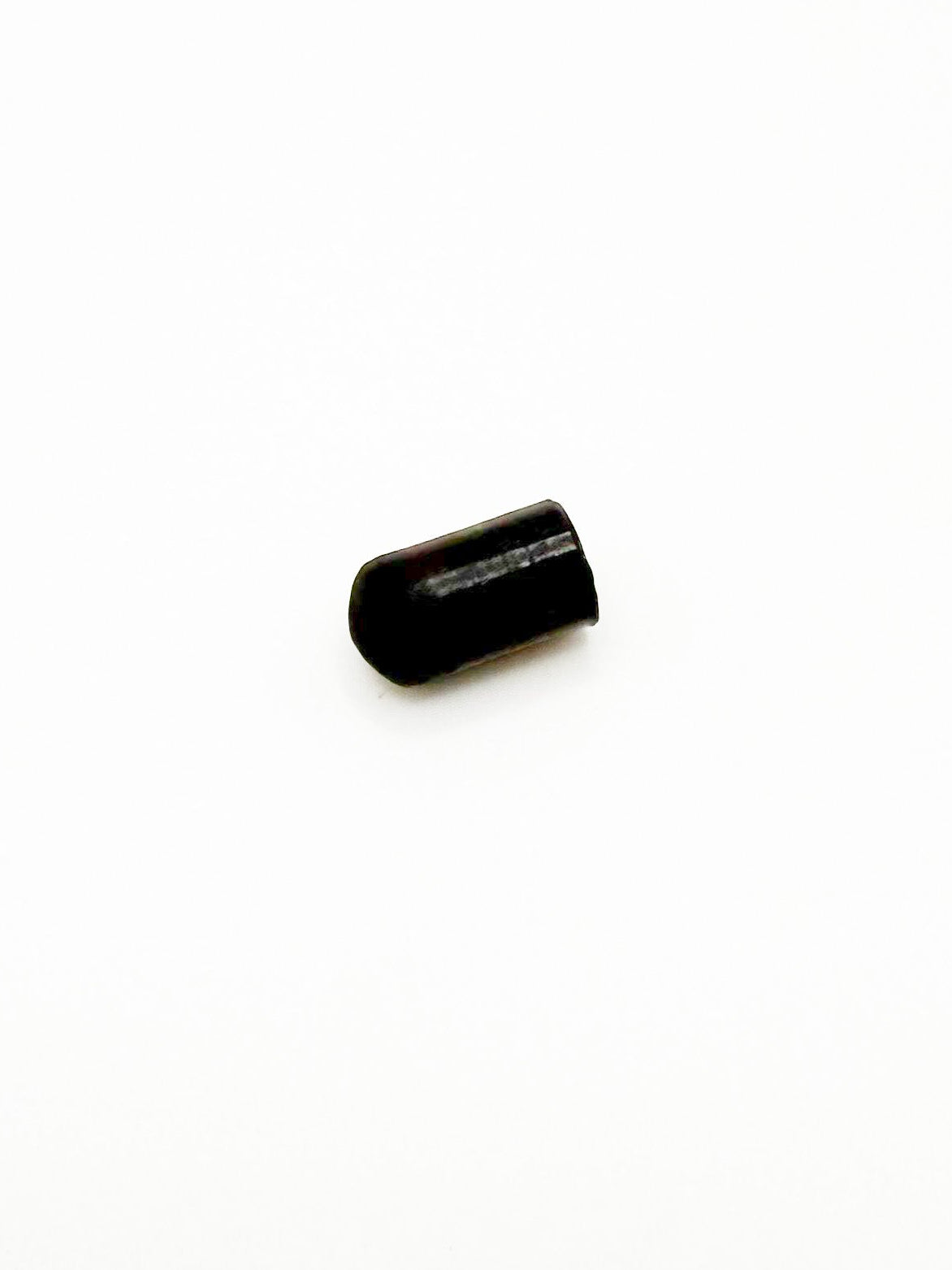 Small black cylindrical object on a white background